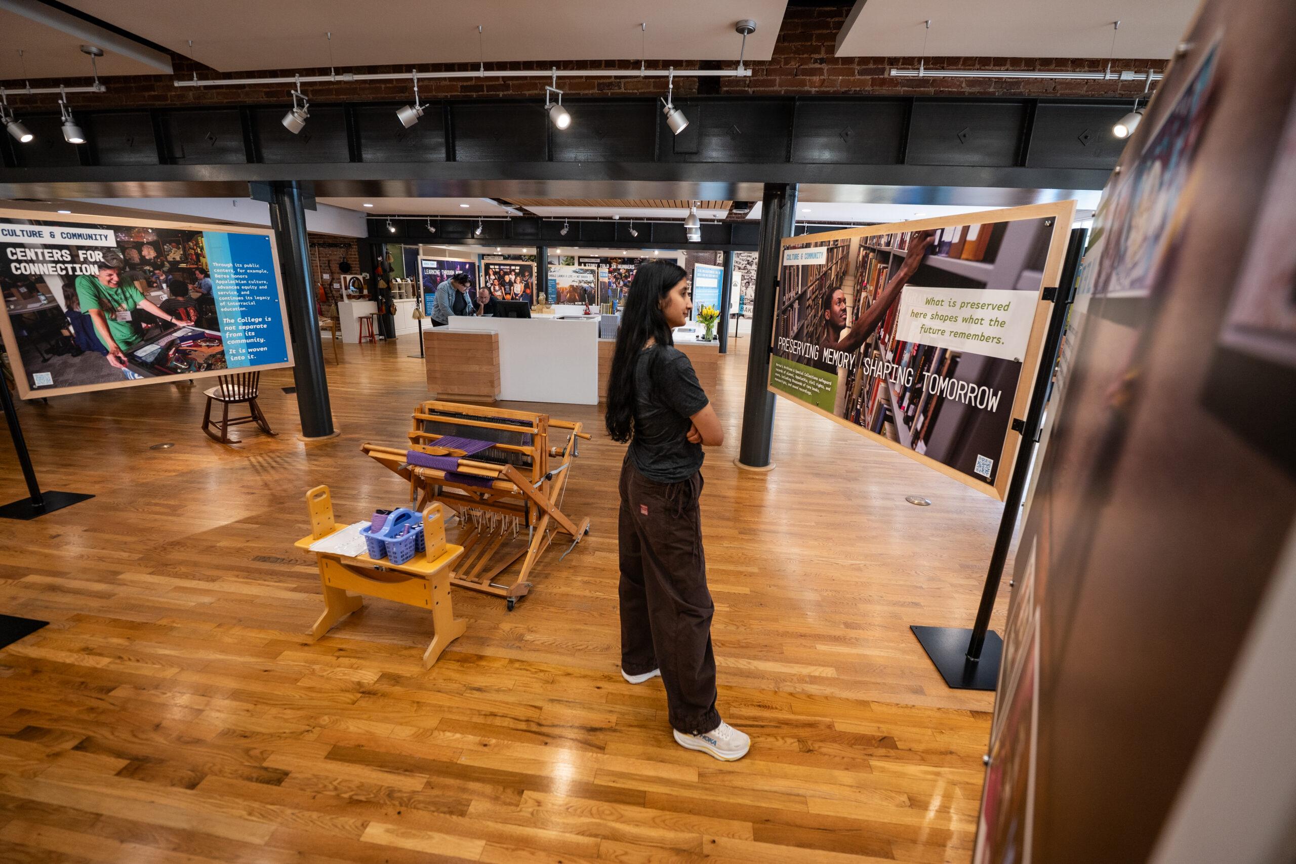 A female student reads a storyboard inside the Berea College Visitor Center